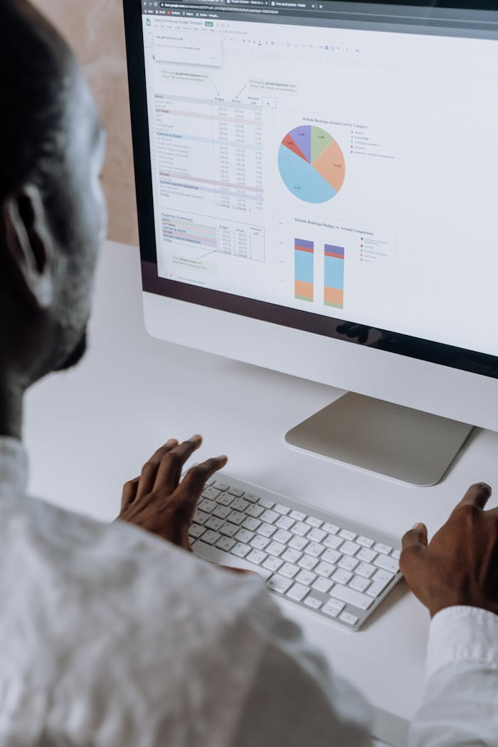 brand-02 Businessman analyzing charts and data on desktop computer in office setting.